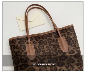 Detailed view of leopard print tote bag with brown leather trim and reinforced stitching