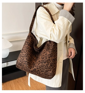 Detailed view of leopard print tote bag with wide shoulder strap worn by a model