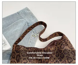 Detailed close-up of leopard print shoulder bag with a focus on its wide strap design