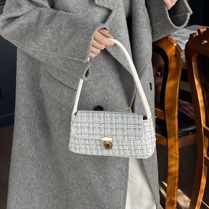 Elegant tweed shoulder bag with golden lock and white handle in a minimalist style