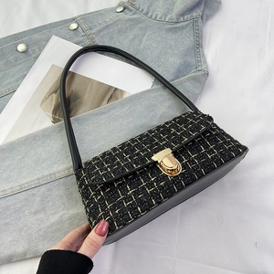 Detail of tweed shoulder bag featuring golden metallic twist lock and black leather strap