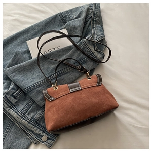 Detail of vintage brown frosted handbag with white contrast stitching and gold ring hardware