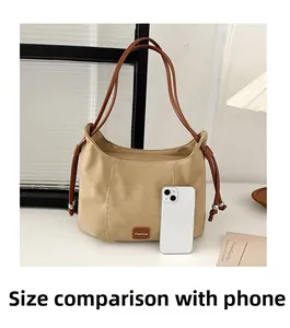 Medium capacity beige hobo bag detail compared to a smartphone to show storage size
