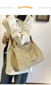 Detail of vintage tote bag with brown leather shoulder straps and brand logo patch