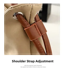Detail of adjustable leather shoulder strap with metal eyelets on chic bicolor bag