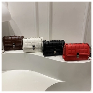 Collection of quilted chain crossbody bags in four colors on a minimalist white display
