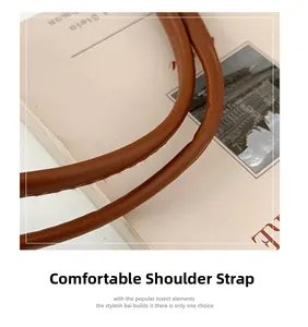Detail view of the brown PU leather shoulder strap with circular design and stitching