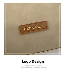Macro detail of beige matte leather tote bag featuring gold-stamped logo on brown patch