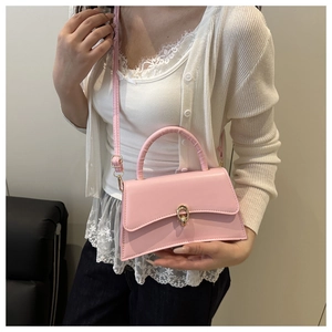 Detail of pink French vintage crossbody bag with gold metal buckle and leather handle