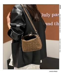 Brown leopard print crossbody bag with metal buckle shown in a stylish street style view