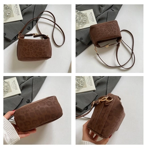 Detail view of brown suede leopard print crossbody bag with gold metallic lock closure