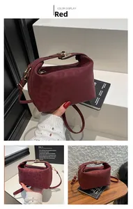 Detail of burgundy leopard embossed bag with gold clasp and textured suede finish