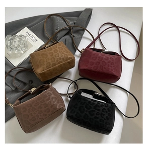 Detailed close-up of leopard pattern texture and metal clasp on crossbody bags