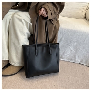 Detailed view of black PU leather tote bag with elegant matte finish and long handles