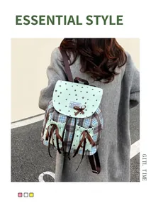 Outdoor shot of mint green and plaid backpack with stars pattern and bow-knot pockets