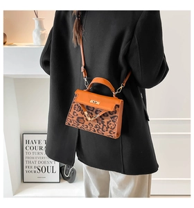 Detail of leopard print handbag with orange flap and gold V-shaped hardware clasp