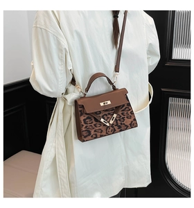Detail of vintage leopard print crossbody bag with golden twist lock and V-metal buckle