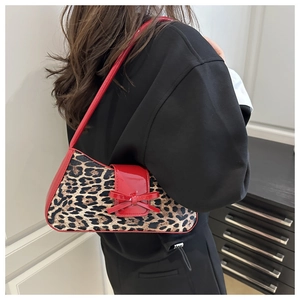 Detail of leopard print shoulder bag with a red patent leather bow and sleek trim