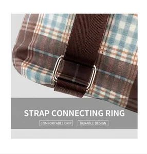 Detail of blue and brown plaid fabric backpack with sturdy metal D-ring and woven strap