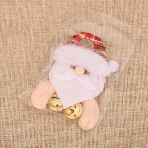 Detailed view of plush Santa Claus ornament with golden bells in a clear OPP package