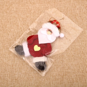Detail of Santa Claus fabric ornament with yellow heart in transparent packaging