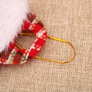 Detail of red and white plaid Christmas ornament with soft faux fur trim and gold string