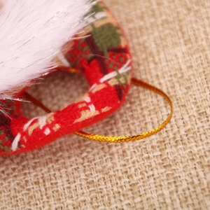 Detail of fabric heart ornament with red plaid pattern and white faux fur trim for Christmas