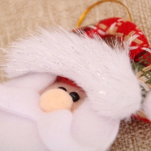 Detail of Santa plush ornament with knitted plaid fabric and fuzzy beard for Christmas tree
