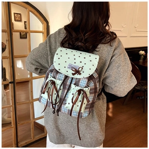 Gros plan d'un sac à dos vintage avec motifs d'étoiles menthe et tissus à carreaux