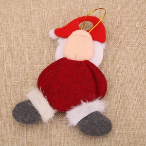 Close-up of handmade Santa Claus plush ornament with red felt hat and golden hanging string