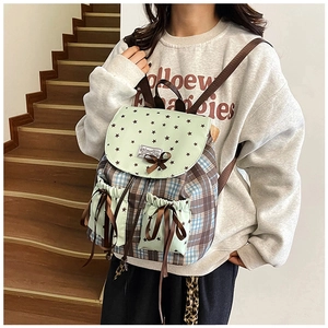 Détail d'un sac à dos vintage à carreaux avec dentelle et nœud sur un escalier
