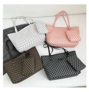 Dettaglio di quattro grandi borse shopper in bianco, rosa, marrone e nero con pochette abbinate