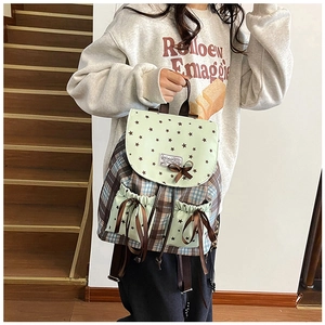 Détail d'un sac à dos style collège en toile verte avec nœud et motif d'étoile imprimé