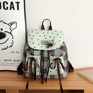 Détail d'un sac à dos d'école vintage avec motif à carreaux, nœud et imprimé d'étoiles