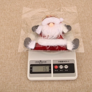 Vue détaillée d'une suspension Père Noël en peluche sur une balance pesant 16g