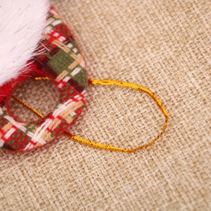 Détail macro d'un ornement de Noël avec tissu à carreaux et bordure en fausse fourrure