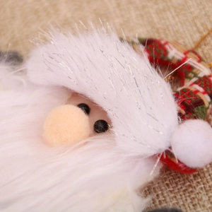 Gros plan d'une peluche Père Noël montrant la barbe blanche et le bonnet à carreaux