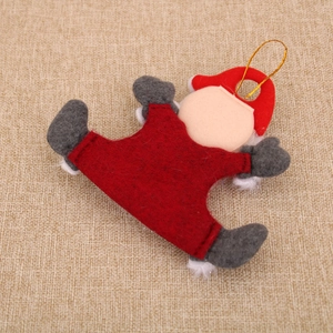 Gros plan d'un lutin de Noël en feutre avec robe rouge et ficelle dorée à suspendre