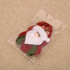 Detail view of felt Santa Claus ornament with gold string in transparent packaging