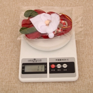 Close-up of a Santa plush ornament on a digital scale showing a weight of 11 grams