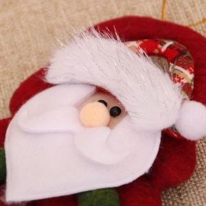Close-up of Santa Claus plush ornament with red felt hat and white fuzzy beard