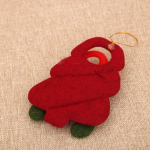 Close-up of red felt Christmas tree ornament with golden string on burlap background