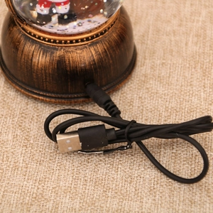 Primer plano de la base decorativa de bronce con puerto USB y cable de corriente