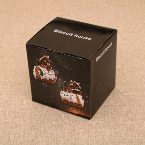 Détail de la boîte cadeau Biscuit House pour Noël avec illustrations de maisons en pain d'épice