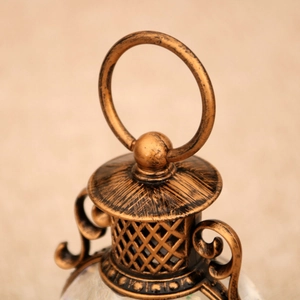 Detalle superior de farol de bronce vintage con anillo colgante y acabado cepillado