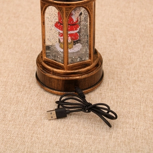 Detail of USB power connection on the antique bronze base of a Santa Christmas lantern