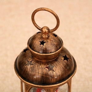 Macro detail of bronze vintage lantern featuring star-shaped cutouts and brushed metal