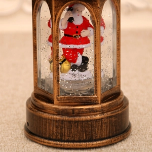 Detail of vintage Christmas lantern with Santa Claus figurine and sparkling glitter snow