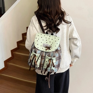 Sac à dos vintage à carreaux avec nœuds en dentelle style scolaire sur l'épaule