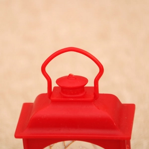 Detail view of red Christmas lantern handle and lighthouse-style top ornament